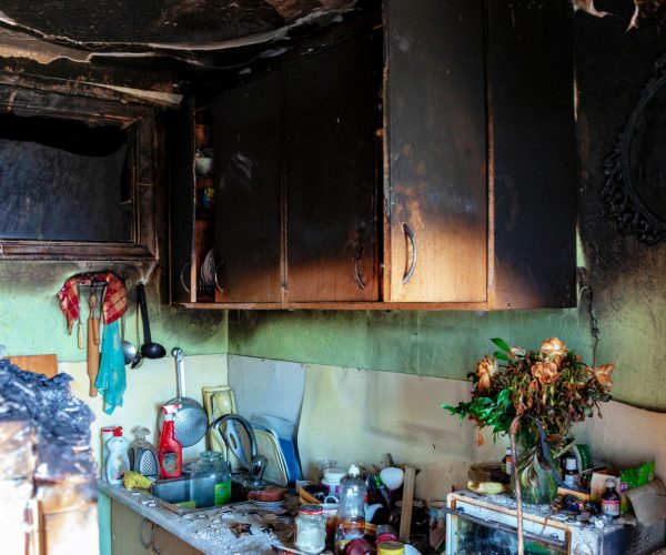 kitchen after the fire, the top black cabinets, a lot of items on the kitchen countertop